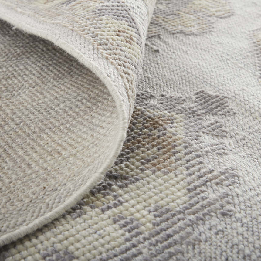Close-up of the Feizy Wendover rug showing the ivory, silver, and tan colors and hand-knotted texture. Fold
