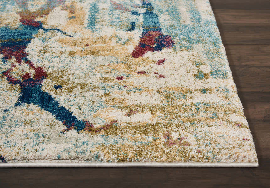 Close-up of Nourison Fusion Cream Multicolor rug showing abstract pattern, cream base, and accents of blue, gold, and red.