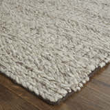 Close-up of the hand woven Feizy Berkeley rug. Ivory, gray, and tan wool rug with chunky, textured geometric pattern. Corner