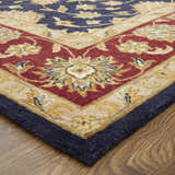 Close-up of the hand-tufted Feizy Wagner Traditional Oriental rug. Features blue, red, and gold floral patterns. Corner