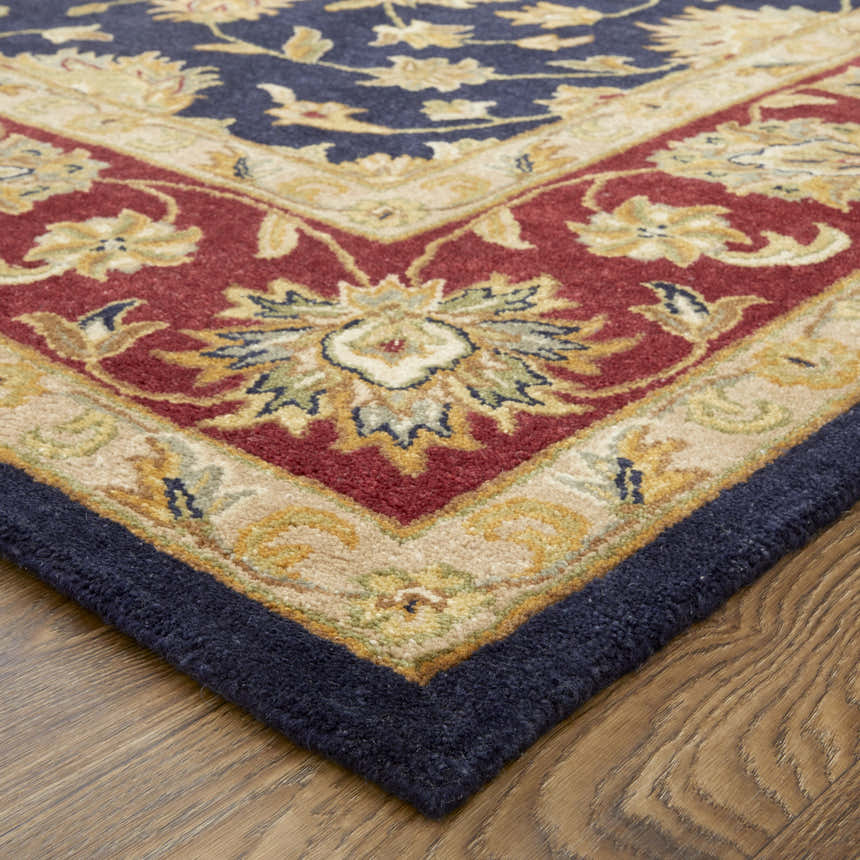 Close-up of the hand-tufted Feizy Wagner Traditional Oriental rug. Features blue, red, and gold floral patterns. Corner
