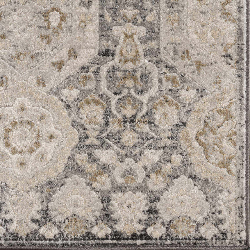 A traditional area rug with hexagonal patterns and floral elements, featuring a blend of black, beige, gray, and mustered tones.