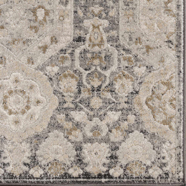 A traditional area rug with hexagonal patterns and floral elements, featuring a blend of black, beige, gray, and mustered tones.