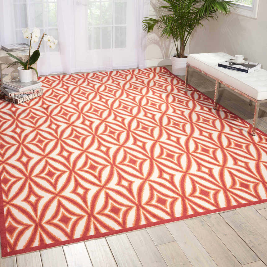 Bright living room with Waverly Sun N' Shade Campari rug, a geometric pattern in red and cream. Mid-century modern style.