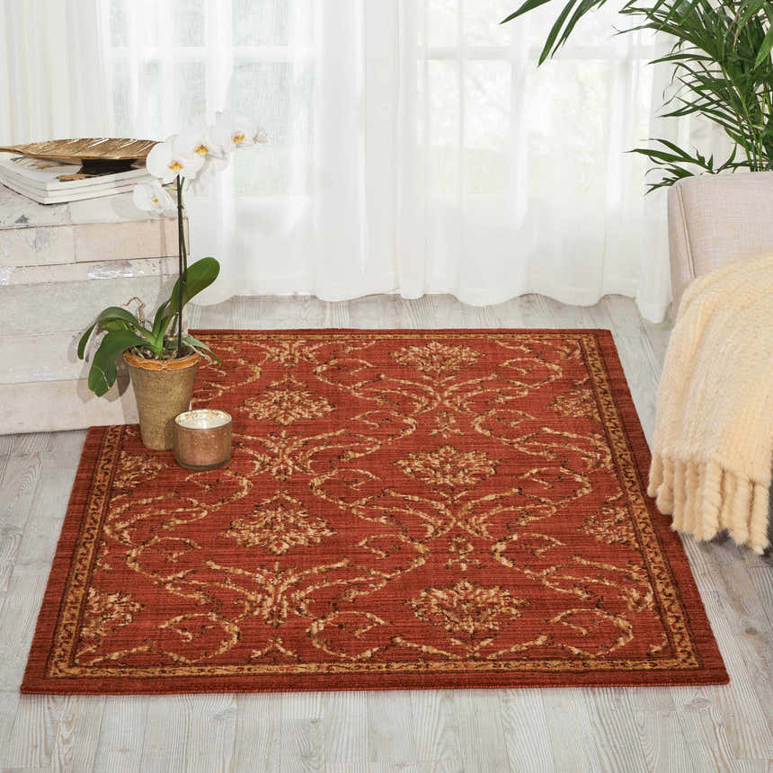 Living room scene with Nourison Radiant Impression Persimmon rug, white orchid, and sheer curtains.