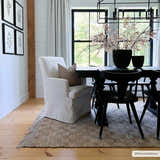 Farmhouse dining room with Ionut Checkered Jute Area Rug, black table and chairs, and a beige armchair. Roomscene-Rectangle