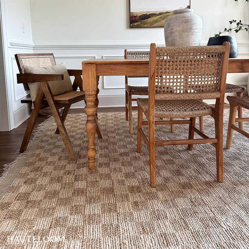 Farmhouse dining room with a beige Ionut Checkered Jute Area Rug under a wood table and woven chairs. Roomscene-Rectangle