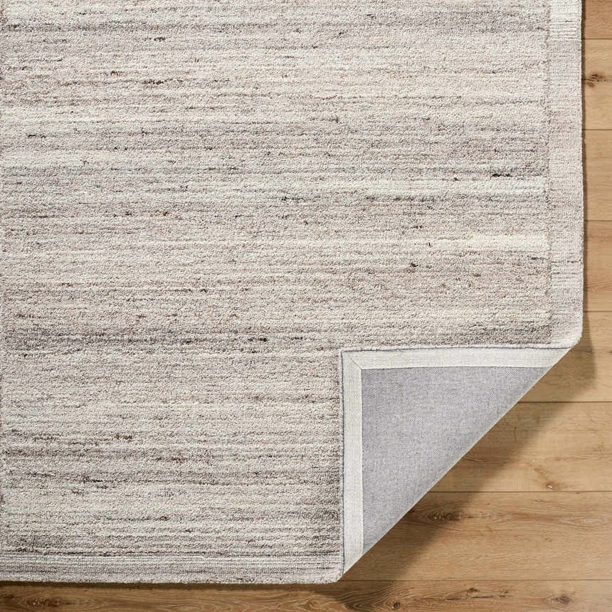 Close-up of the Blenda Beige Area Rug. Hand-tufted wool rug with horizontal beige, charcoal, and light gray striations. Fold