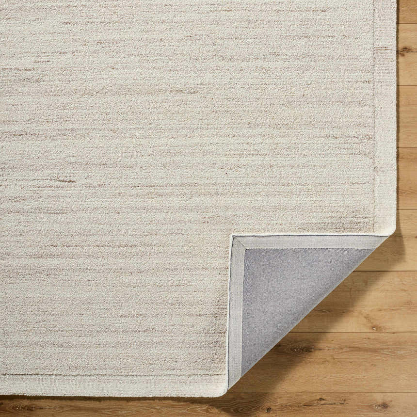Close-up of the Blenda Tan Area Rug showing its beige, cream, and tan wool texture and hand-tufted construction. Fold