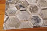 Close-up of the handmade Michael Amini City Chic Silver Area Rug with a geometric hexagon pattern and leather texture.