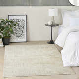 Modern bedroom scene with DKNY Grand Street Ivory Beige rug, white bedding, black side table and abstract art.