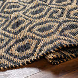 Close-up of the hand woven Isaye Charcoal Area Rug, featuring a dark beige and gray contemporary pattern. Fold