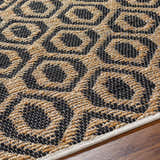 Close-up of the hand-woven Isaye Charcoal Area Rug, featuring a geometric pattern in jute and black recycled fabric. Texture