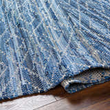 Close-up of the hand woven Gurit Blue Area Rug. Recycled fabric in shades of blue, gray, and white. Contemporary style. Fold