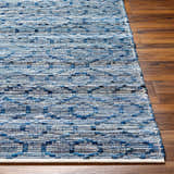 Close-up of the hand woven Gurit Blue & Brown Area Rug showing textures and shades of blue on a wood floor. Front