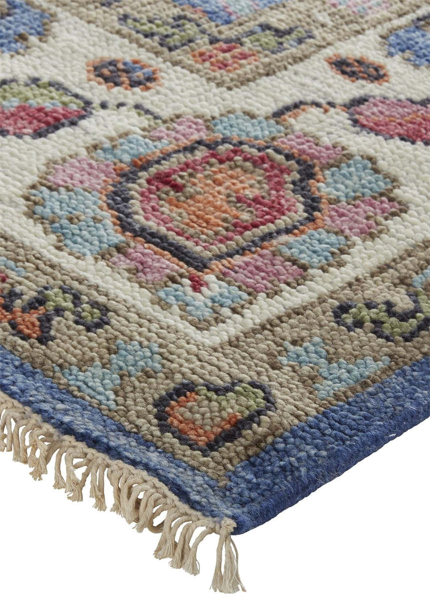 Close-up of the hand-knotted Feizy Beall rug. Traditional oriental design in blue, red, and cream with fringe detail. Corner