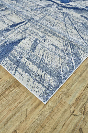 Close-up of Feizy Brixton rug. Modern abstract design in blue and ivory on wood floor. Contemporary style. Corner
