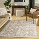 Living room scene with a light brown Nourison Isla Mocha vintage rug, sofa, and leather chair.