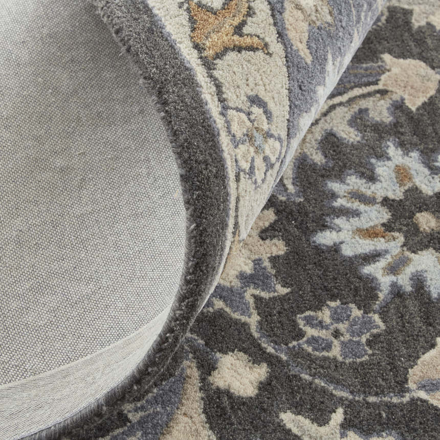 Close up of the Feizy Rylan Taupe/Blue/Ivory Area Rug showing wool texture, floral pattern, and cotton backing. Fold