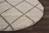 Close-up of a cream shag Nourison Brisbane rug with a diamond pattern on a dark wood floor.