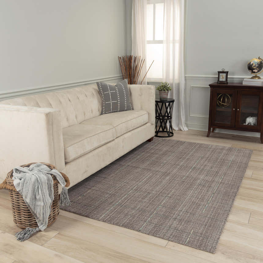 Living room scene with Rizzy KIK691 area rug in gray. Farmhouse style with a cream sofa, wood cabinet, and light wood floors. Roomscene-Rectangle