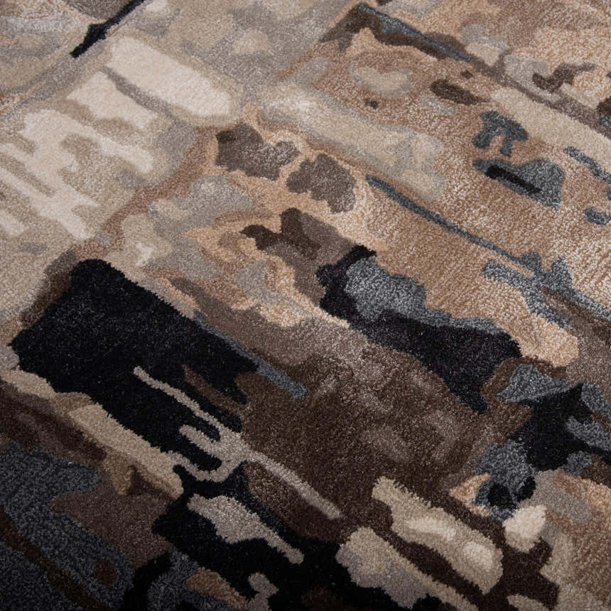 Close-up of the Rizzy KIN533 area rug. Abstract design in beige, charcoal, dark brown, ivory and gray. Hand-tufted wool blend. Texture