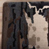 Close-up of Rizzy KIN533 area rug showing beige, charcoal, brown, and ivory abstract pattern and hand-tufted wool texture. Corner