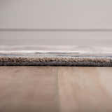 Close-up of Rizzy KIN533 area rug showing beige, charcoal, and brown tones. Hand-tufted wool and tencel texture. Pile