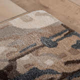Close-up of Rizzy KIN533 area rug. Beige, charcoal, and brown contemporary pattern. Hand-tufted wool and tencel texture. Fold