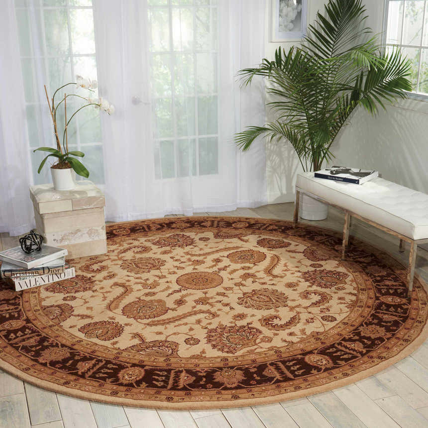 Bright room scene with a round Nourison Heritage Hall Beige Persian rug, white bench, and sheer curtains.