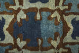 Close-up of the Feizy Amzad Ikat rug, showing a blue, gray, and tan geometric pattern in hand-knotted wool. Texture