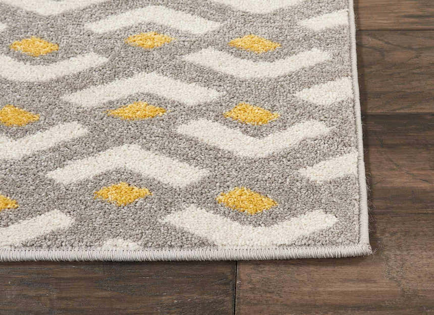 Close-up of Nourison Harper Grey Colorful rug. Features a gray, white, and yellow geometric design.