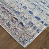 Close-up of Feizy Edgemont rug. Abstract design in blue, ivory, and orange on a textured surface. Casual, contemporary style. Corner