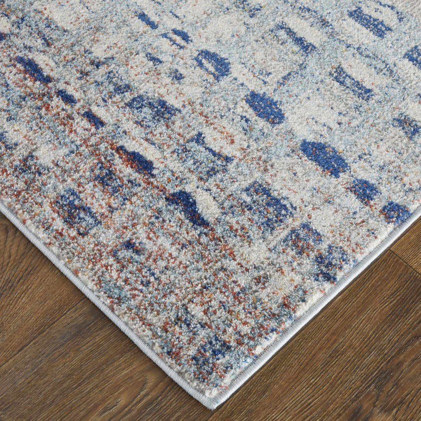 Close-up of Feizy Edgemont rug. Abstract design in blue, ivory, and orange on a textured surface. Casual, contemporary style. Corner