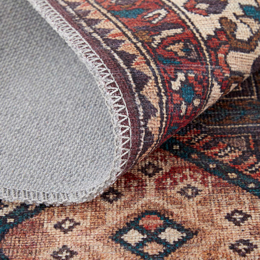 Close up of Feizy Rawlins rug showing the oriental pattern, brown, red, ivory colors, and the rug's backing. Fold