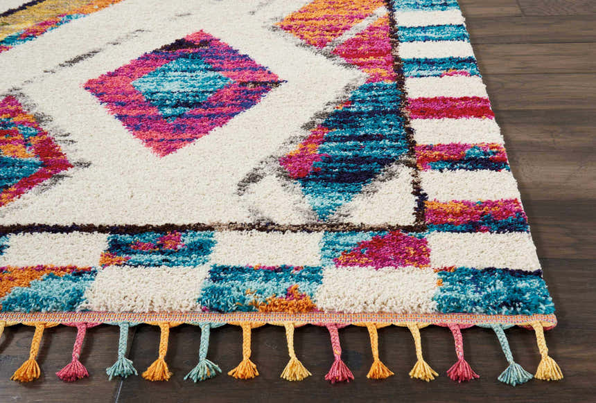 Close-up of Nourison Nomad Ivory Multicolor Tribal rug. Features diamond and square patterns, plus colorful tassels.