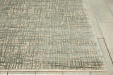 Close up of Nourison Starlight Sea Mist rug showing its light beige and gray grid pattern and soft texture.