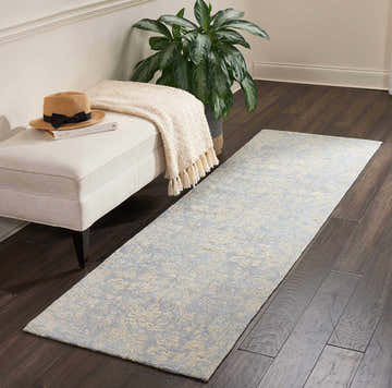 Entryway with Waverly Vintage Lux Mist runner rug, cream bench, hat, blanket, plant, and dark wood floors.
