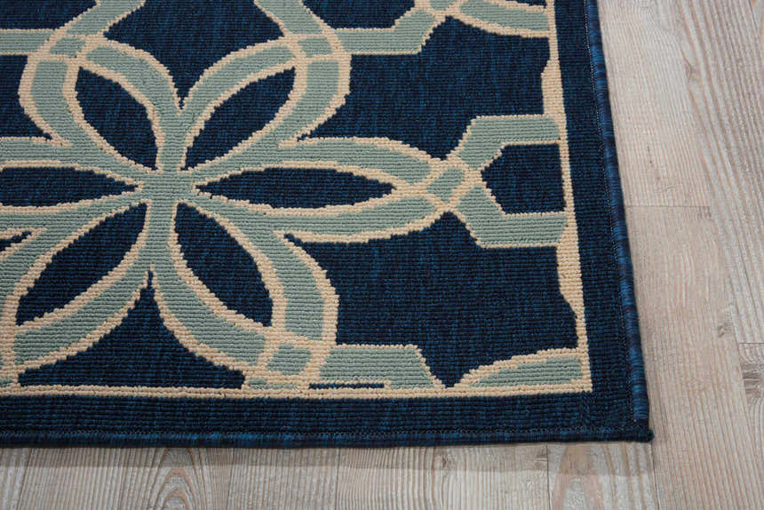 Close up of Nourison Caribbean Navy rug showing geometric floral pattern in navy, light blue, and beige.