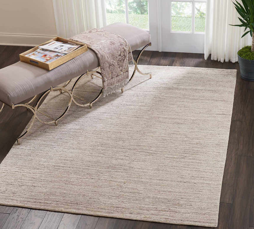 Entryway with a bench and the Nourison OCEAN Sand modern rug on dark wood floors.