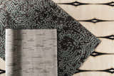 Close-up of three rugs: Pensacola Denim/Black rug with blue dots, gray geometric rug, and tan rug with black pattern. Styleshot