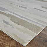 Close up of the Feizy Vancouver rug, showcasing its ivory, tan, and brown abstract design and soft texture. Corner