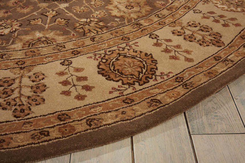 Close up of the Nourison 3000 Taupe Persian rug showing floral patterns and a border on a light wood floor.