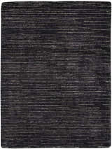 Close-up of the Nourison OCEAN Onyx rug. Black rug with a subtle horizontal stripe pattern and textured, handmade construction.