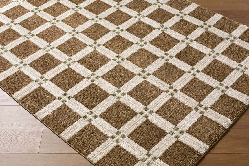 Close-up of the Kalkin Brown Area Rug. Features a geometric diamond pattern in dark brown, off-white, and olive green. Corner