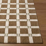 Close up of the Kalkin Brown Area Rug showing its brown, off-white, and olive square pattern and machine woven texture. Front