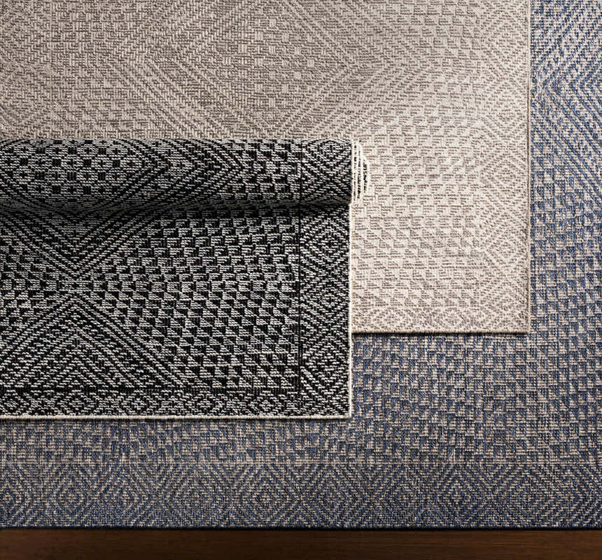 Close-up of Lusacan Area Carpet in charcoal, gray, and off-white. Hand-knotted rug with a geometric pattern. Viscose texture. Styleshot
