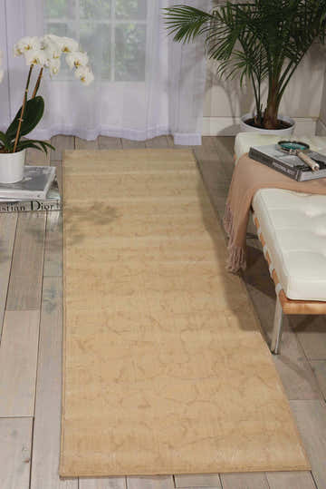 Living room scene with a beige Nourison Nepal Bone Vintage area rug, white couch, and potted plants.