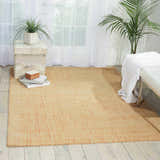 Light-filled room with a peach Barclay Butera Intermix Wheat rug, white bench, and plants.