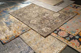 Close-up of various rugs, including the Dalupaon Area Rug, showcasing floral, oriental, and traditional patterns in beige, gray, and blue tones. Styleshot